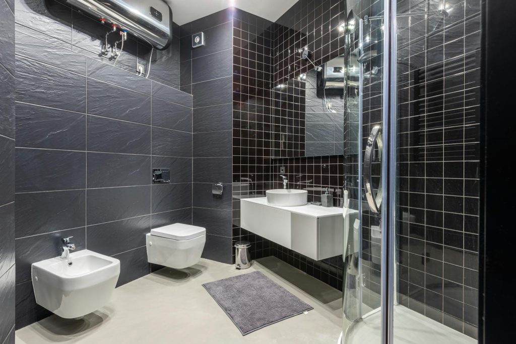 Interior design of modern bathroom with shower and bidet decorated with black tile