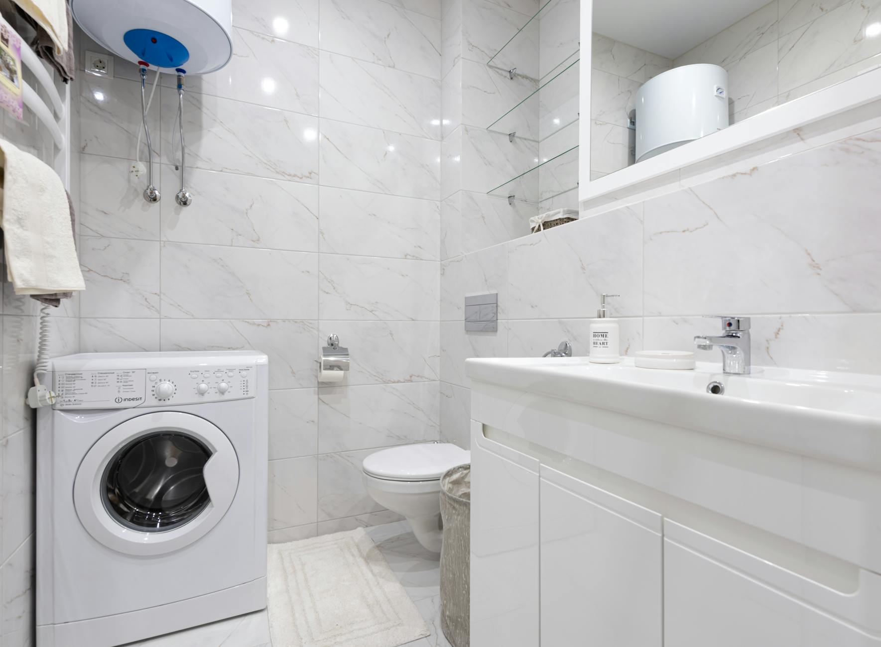 Bright minimalist bathroom featuring a washing machine and modern fixtures.