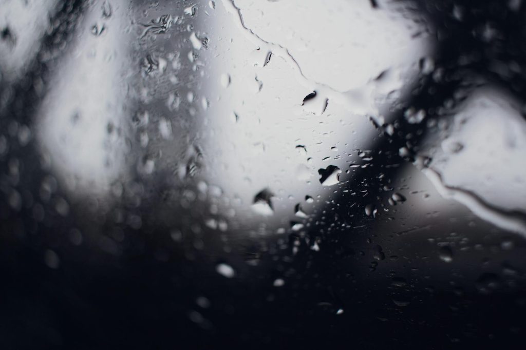 A close-up view of raindrops on a window in New York City, showcasing a moody and atmospheric scene.