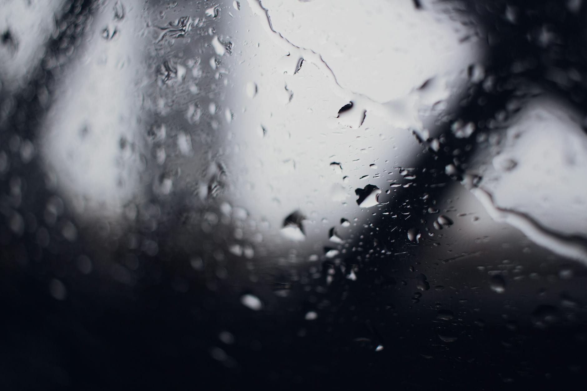 A close-up view of raindrops on a window in New York City, showcasing a moody and atmospheric scene.