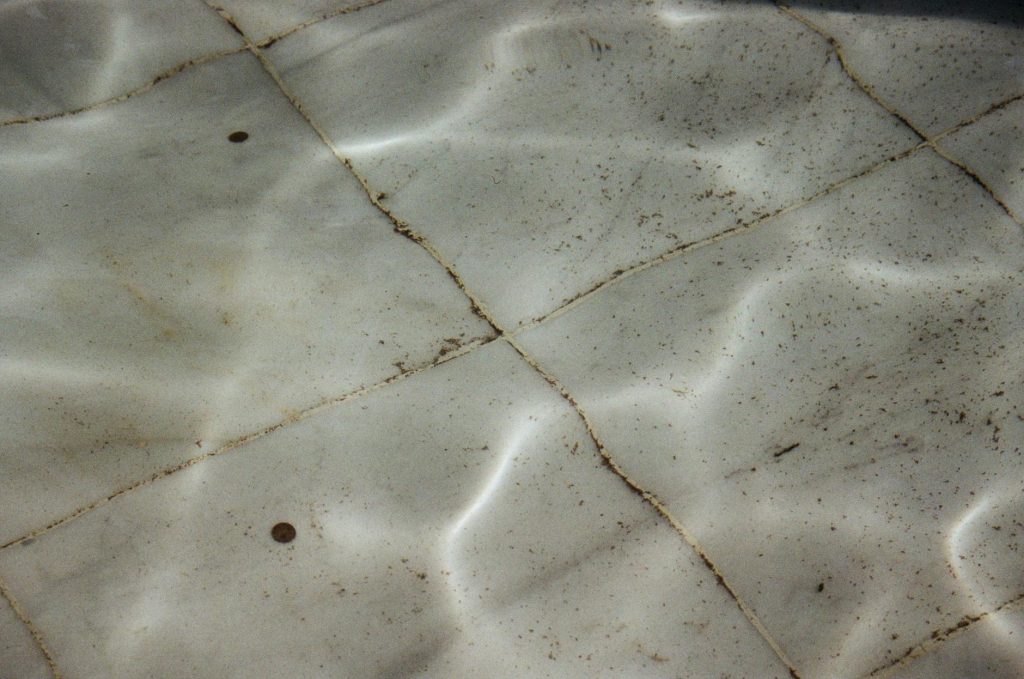 Detailed view of dirty, textured swimming pool tiles underwater in Saint Petersburg, Russia.