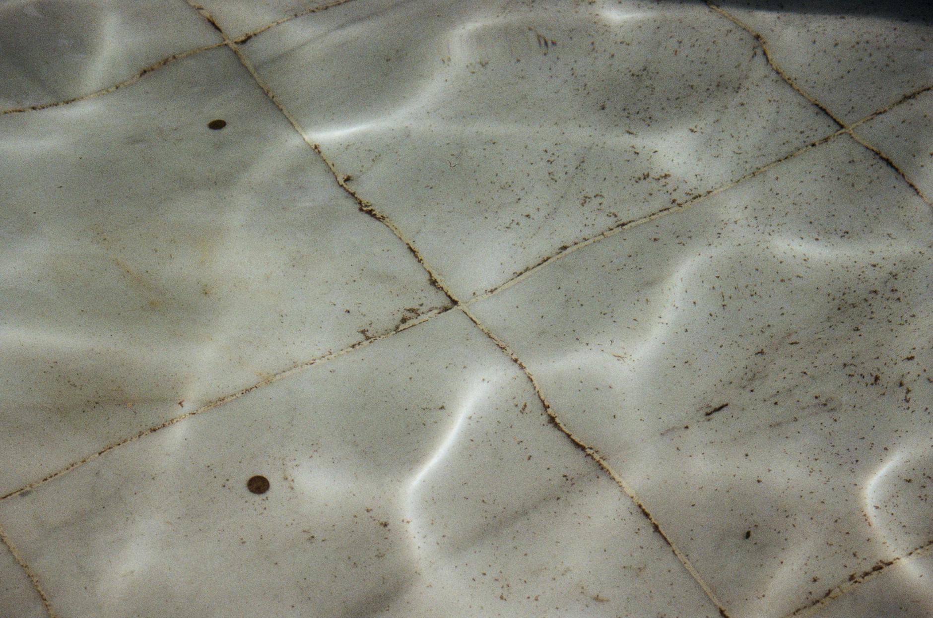 Detailed view of dirty, textured swimming pool tiles underwater in Saint Petersburg, Russia.