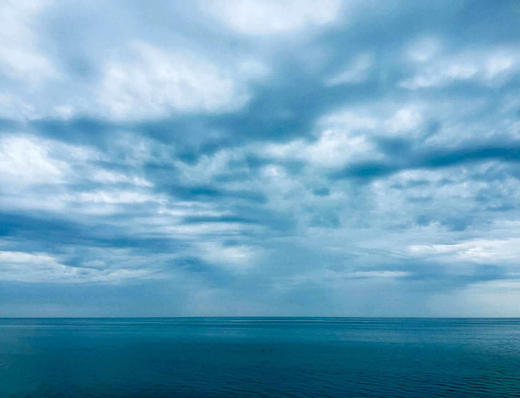 A serene ocean scene with a vast cloudy sky, capturing the tranquility of nature.